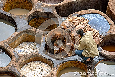 FEZ, MOROCCO â€“ APRIL 10, 2016: The incredible historical tannery in Fez, Morocco. Workers painting leather in Morocco, Africa o Editorial Stock Photo